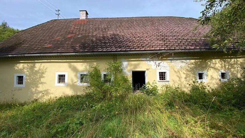 gelbes Sacherl. altes Bauernhaus mit kleinen vergitterten Fenstern